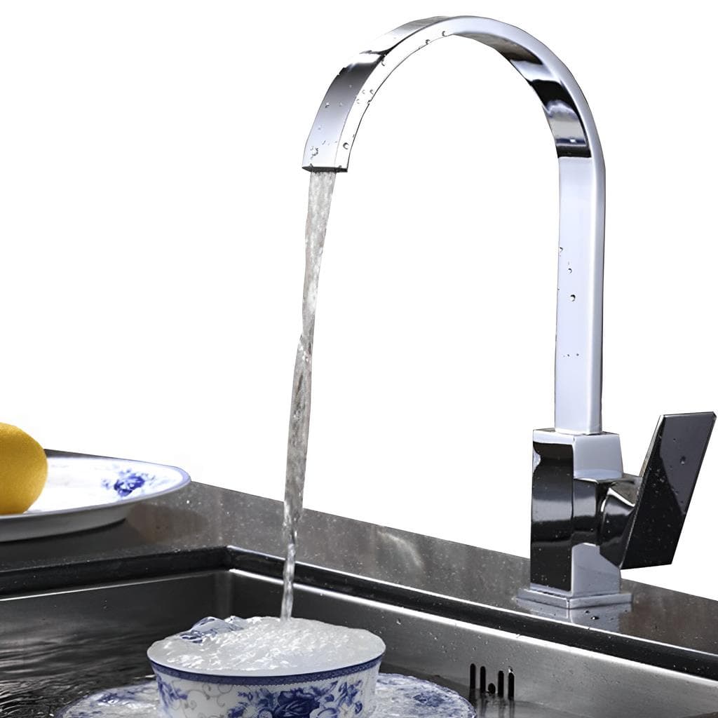 Torneira de cozinha slim em aço inoxidável com cascata, água fluindo para um recipiente azul e branco, limão na placa ao fundo