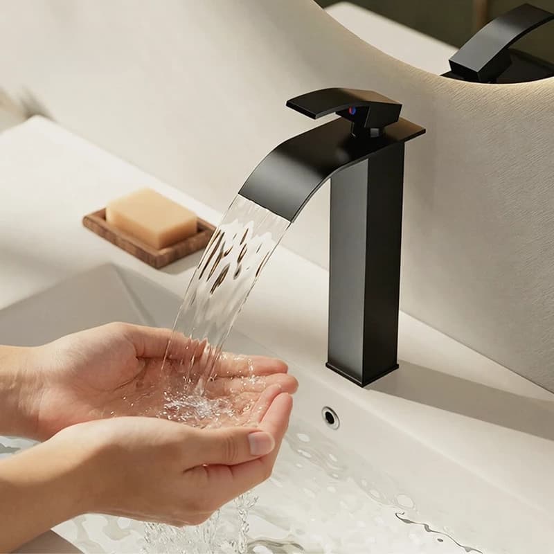 Torneira de banheiro preta com design de cascata em pia branca