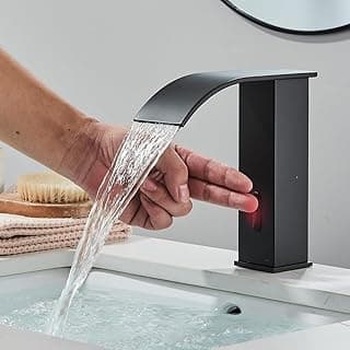 Torneira de banheiro preta com sensor de toque, design elegante, fluxo de água, lavatório branco, espelho circular, escova de cabelo.